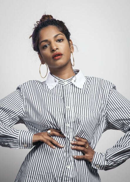 A confident Mia rapper in a black and white striped shirt posing with her hands on her waist, 2K Mobile Wallpaper