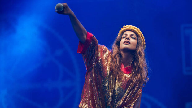 Mia rapper performs passionately with a microphone during a concert, HD Desktop Wallpaper