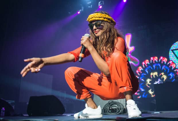 Mia rapper performing on stage with microphone during concert, 2K Desktop Wallpaper