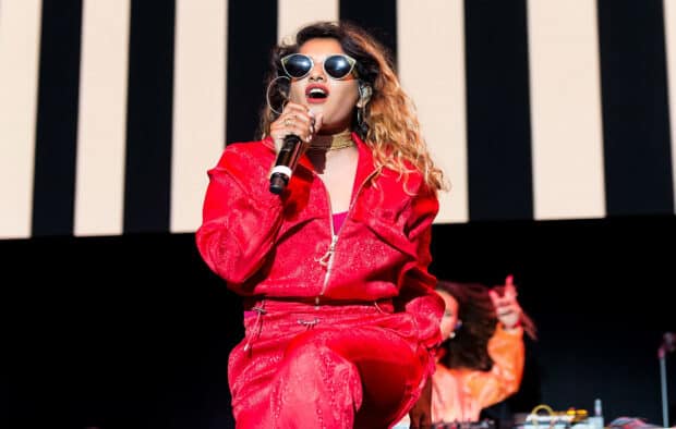 Mia rapper performing live in a red outfit with sunglasses, HD Desktop Wallpaper