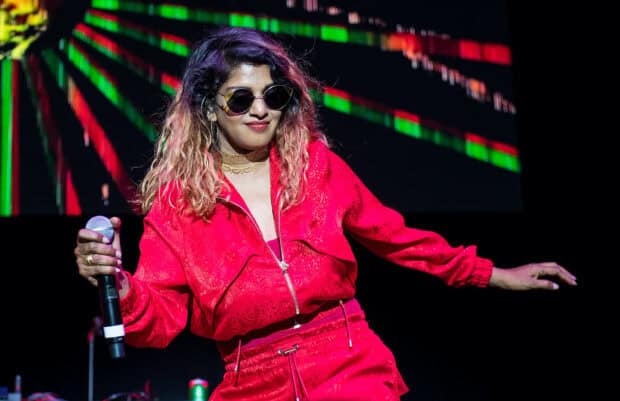 Mia rapper is wearing red and holding a microphone while performing on stage, HD Desktop Wallpaper