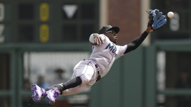 A Miami Marlins player is fully extended while catching a baseball during a game, HD Desktop Wallpaper