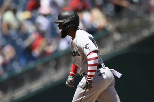 A Miami Marlins player wearing a helmet celebrates during a baseball game, HD Desktop Wallpaper