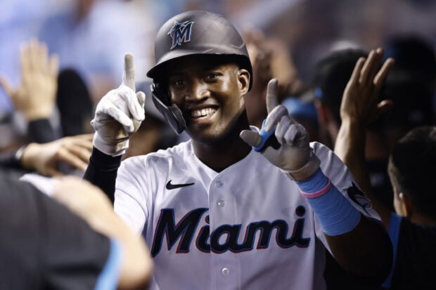 A Miami Marlins player is smiling and celebrating with teammates after a successful play, 2K Desktop Wallpaper