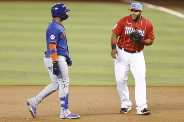 A Miami Marlins player interacts with an opposing team member during a baseball game on the field, 2K Desktop Wallpaper