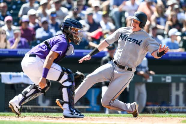 A Miami Marlins player is sliding into a base while an opposing catcher prepares to tag him during a game, 2K Desktop Wallpaper