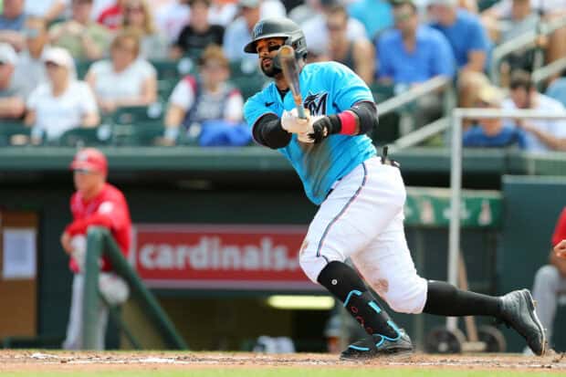 A Miami Marlins player is swinging the bat during a baseball game in front of cheering fans, 2K Desktop Wallpaper