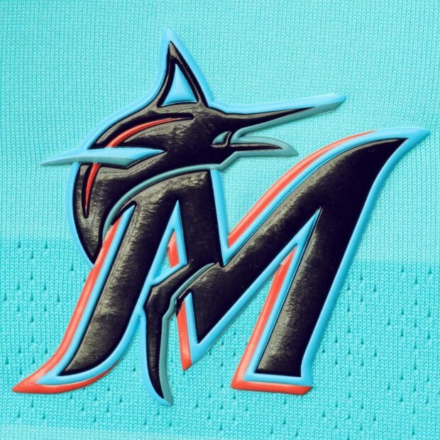 The Miami Marlins logo is displayed on a textured surface, HD Desktop Wallpaper