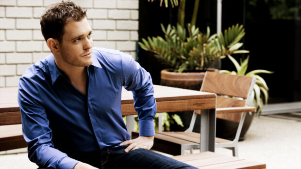 Michael Buble wears a blue shirt sitting on a wooden bench looking sideways, HD Desktop Wallpaper