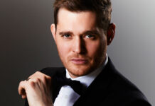 Michael Buble wearing a tuxedo while adjusting his bow tie in a portrait, 2K Desktop Wallpaper