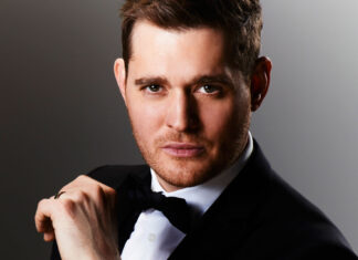 Michael Buble wearing a tuxedo while adjusting his bow tie in a portrait, 2K Desktop Wallpaper
