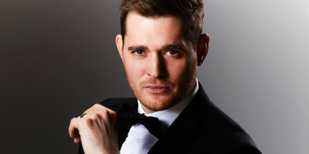 Michael Buble wearing a tuxedo while adjusting his bow tie in a portrait, 2K Desktop Wallpaper