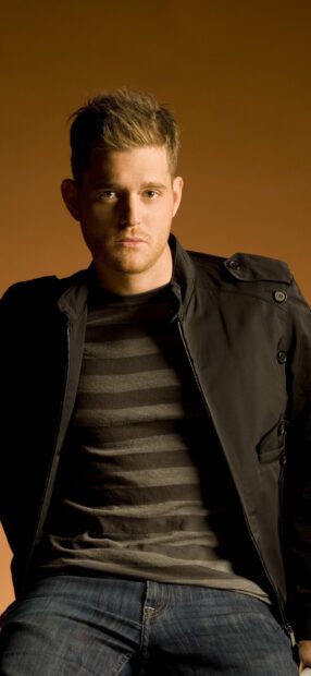 Michael Buble wallpapers showing him wearing a striped shirt and dark jacket sitting against an orange background, HD Phone Wallpaper