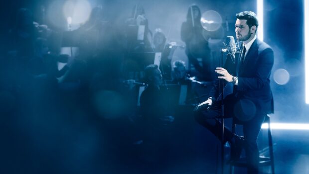 Michael Buble performs a live song with an orchestra in a blue lit setting, HD Desktop Wallpaper
