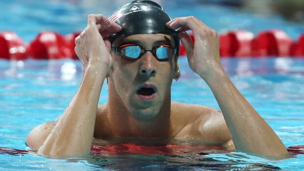 Michael Phelps adjusting his swim goggles while in the pool during a swim event, HD Desktop Wallpaper