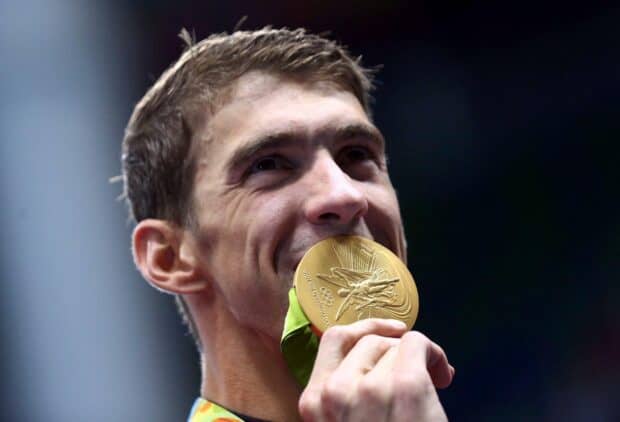 Michael Phelps holding and kissing his Olympic gold medal with joy, HD Desktop Wallpaper