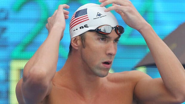 The image shows Michael Phelps adjusting his swim cap before a race, HD Desktop Wallpaper