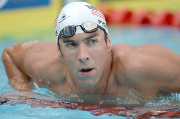 Michael Phelps focused in the pool wearing his swim cap and goggles during a competition, HD Desktop Wallpaper
