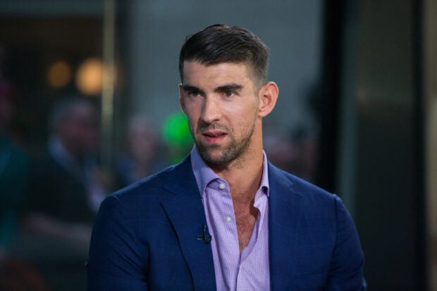 Michael Phelps is wearing a blue suit and speaking during an event, 2K Desktop Wallpaper