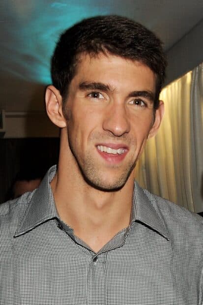 A close up portrait of Michael Phelps smiling in a checkered shirt at an indoor event, 2K Mobile Wallpaper