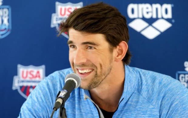 Michael Phelps is smiling and speaking into a microphone during a press event, HD Desktop Wallpaper