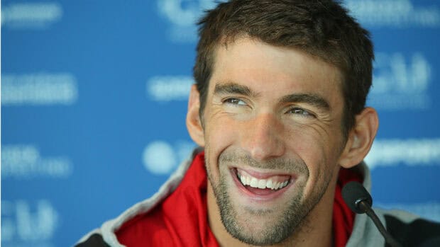 Michael Phelps is smiling during a press conference with a microphone in front of him, HD Desktop Wallpaper