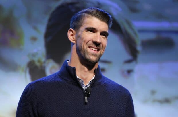 Michael Phelps smiles while speaking at an event wearing a dark textured sweater, 2K Desktop Wallpaper