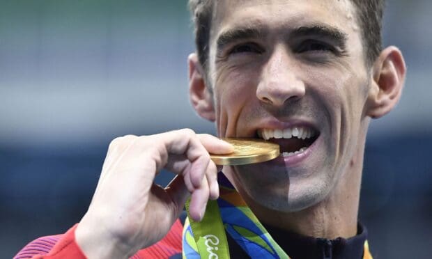 Michael Phelps is celebrating a gold medal victory with a bright smile, HD Desktop Wallpaper