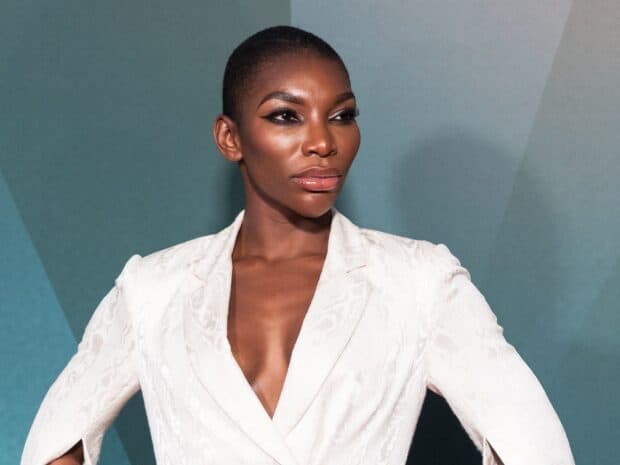Michaela Coel wearing a white blazer with a confident expression, HD Desktop Wallpaper