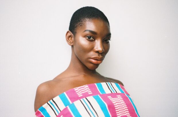 Michaela Coel wallpapers showing a confident expression in colorful clothing, HD Desktop Wallpaper