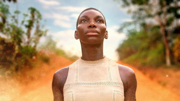 Michaela Coel looks confidently into the distance with a natural setting behind her, 4K Desktop Wallpaper