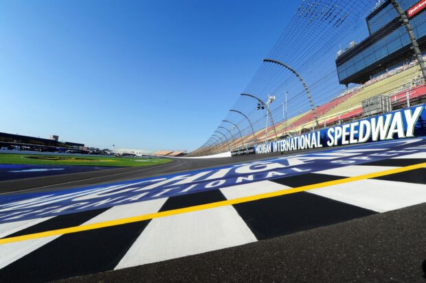 The race track features Michigan International Speedway with a checkered finish line under a clear blue sky, 2K Desktop Wallpaper