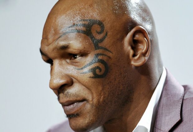 Mike Tyson shows a facial tattoo in a thoughtful pose, HD Desktop Wallpaper