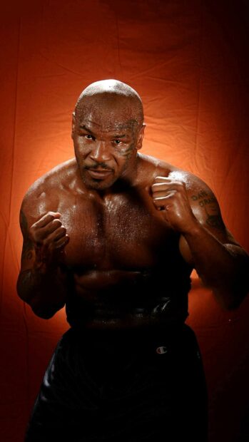 Mike Tyson shows a strong fighting stance with sweat on his body and a focused expression, HD Phone Wallpaper