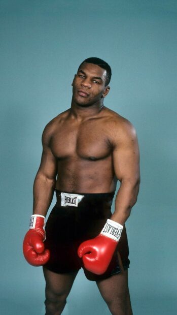Mike Tyson is posing confidently wearing red gloves and black shorts, HD Mobile Wallpaper