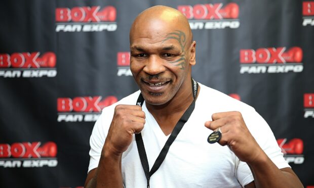 Mike Tyson smiles and poses with raised fists at a fan expo event, 2K Desktop Wallpaper