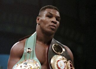 Mike Tyson stands in the ring wearing multiple championship belts after a fight, 2K Mobile Wallpaper