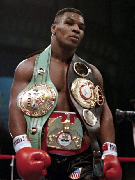 Mike Tyson stands in the ring wearing multiple championship belts after a fight, 2K Mobile Wallpaper