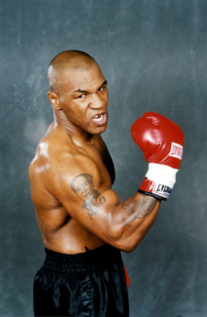 Mike Tyson with red boxing gloves poses fiercely against gray background, 2K Mobile Wallpaper