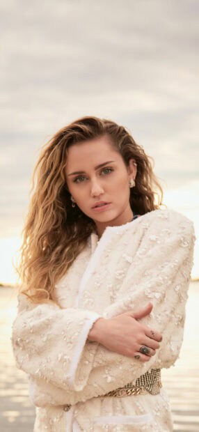 Miley Cirus wallpapers show her in a light embroidered jacket by the water, HD Mobile Wallpaper