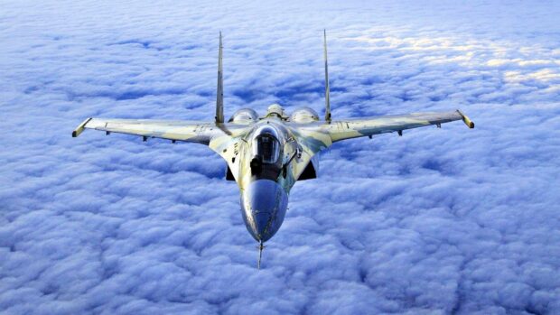 A jet fighter flies high above dense clouds during flight, HD Desktop Wallpaper
