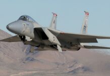 The jet fighter is flying low above a dry mountain range with clear skies, HD Desktop Wallpaper
