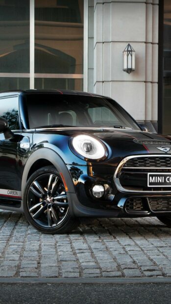 A sleek black Mini Cooper is parked on cobblestone, showcasing its stylish front design, HD Phone Wallpaper