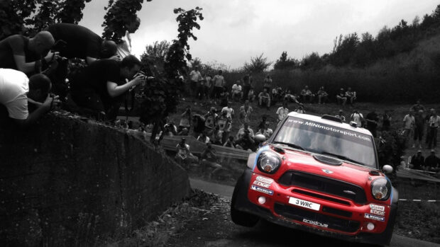 A Mini Cooper races in a rally surrounded by fans and photographers, HD Desktop Wallpaper