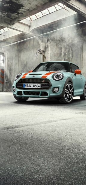 A Mini Cooper with orange stripes is parked in an industrial garage, 2K Phone Wallpaper