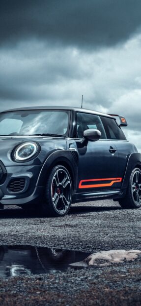 A sporty Mini Cooper with gray body and orange decals under a cloudy sky, 2K Phone Wallpaper