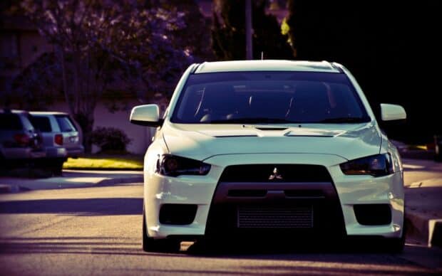A white Mitsubishi Lancer Evo car is parked on a street in the afternoon light, HD Desktop Wallpaper