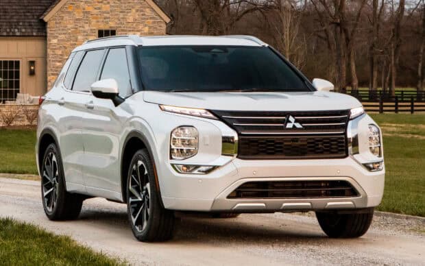 A white Mitsubishi Outlander drives on a driveway near a house, HD Desktop Wallpaper