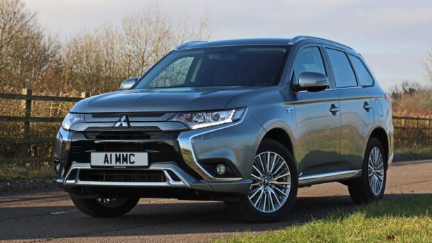 A Mitsubishi Outlander is parked on a rural road with trees in the background, HD Desktop Wallpaper
