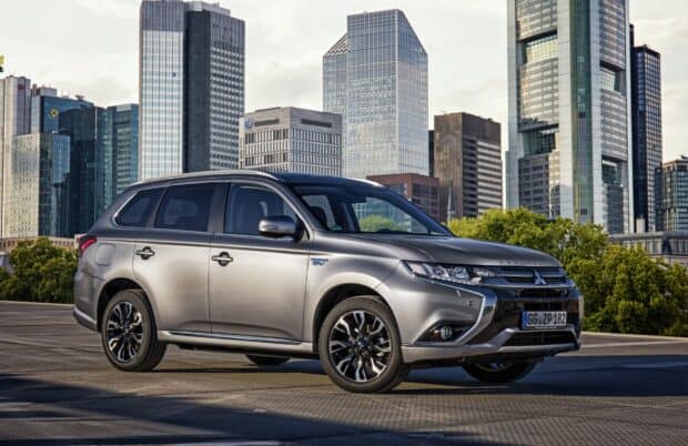 A silver Mitsubishi Outlander is parked with city skyscrapers in the background, HD Desktop Wallpaper